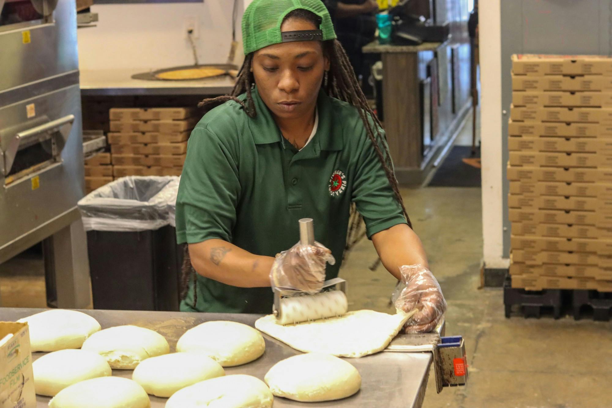 Quinotrese Johnson, a general manager at Stoner’s pizza, rolls dough on March 25, 2022. Johnson said she believes strongly in providing assistance to those in need and uses her position to help out in any way she can.