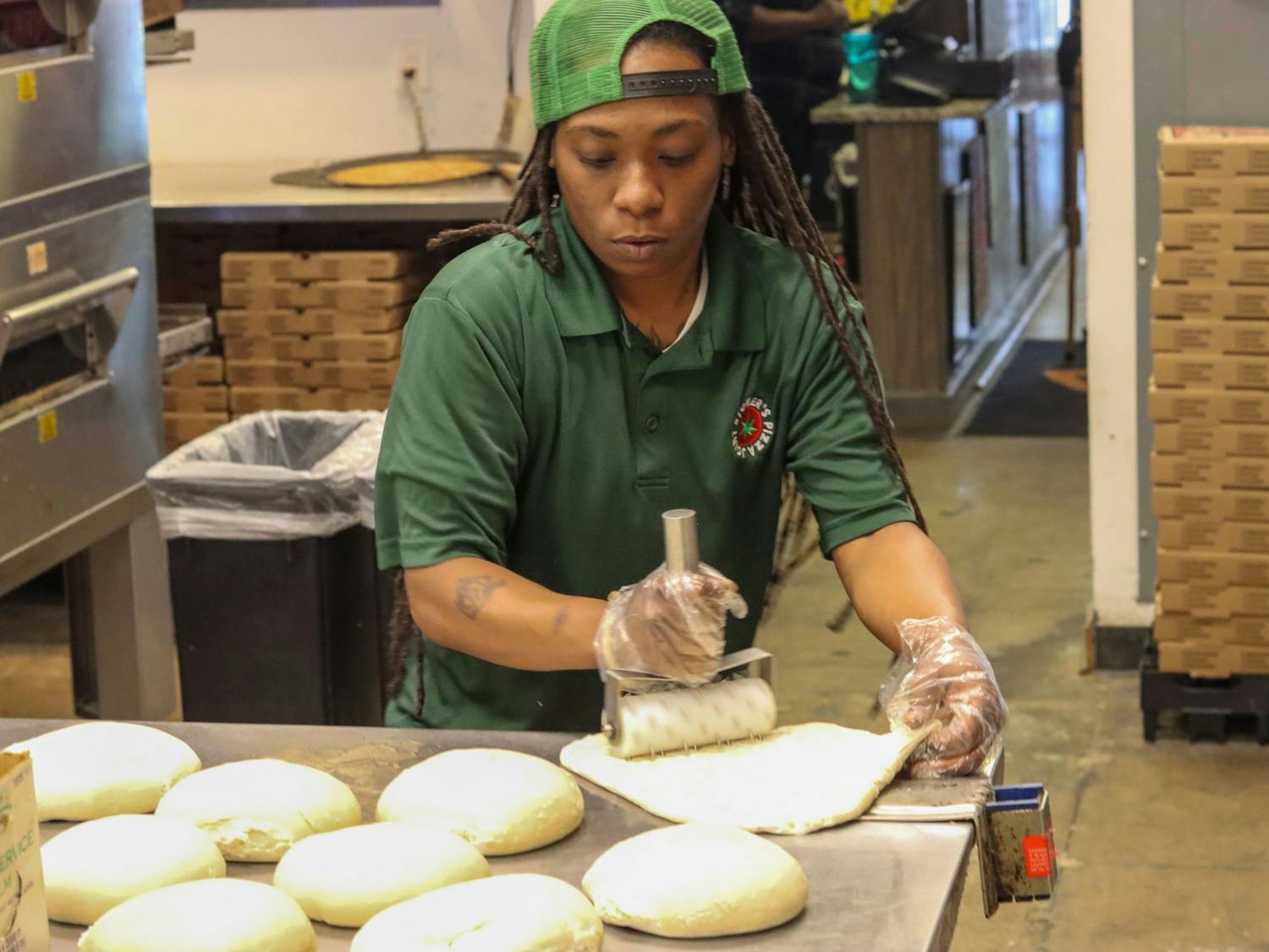 Quinotrese Johnson, a general manager at Stoner’s pizza, rolls dough on March 25, 2022. Johnson said she believes strongly in providing assistance to those in need and uses her position to help out in any way she can.