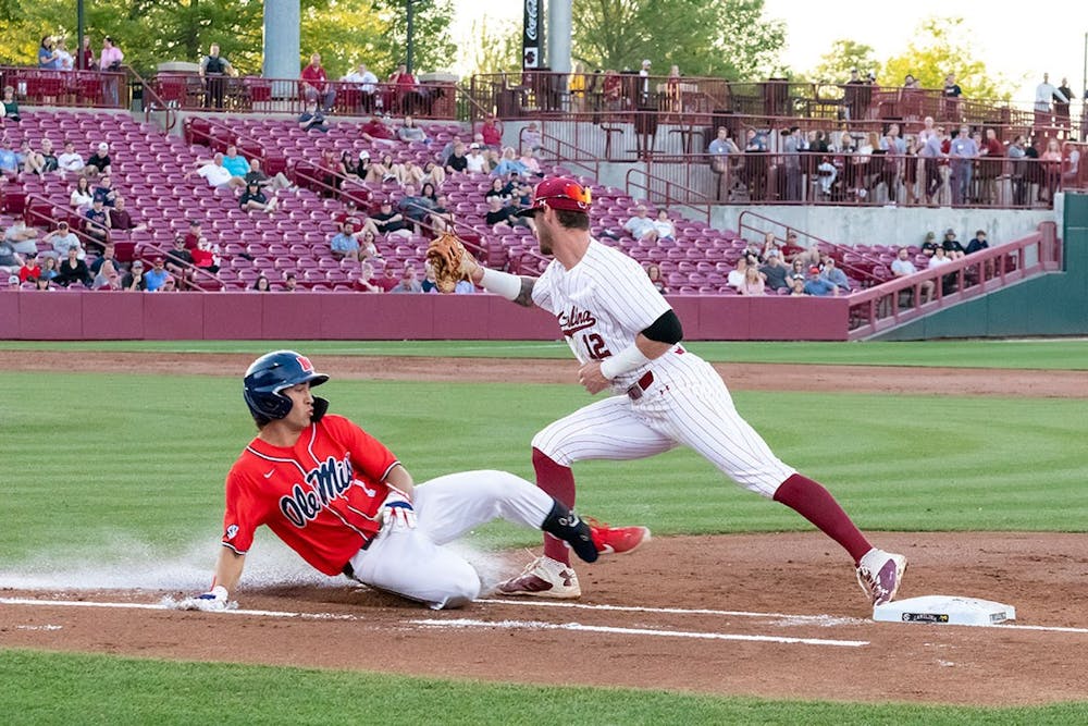 Ole Miss Junior infielder Peyton Chatagnier (on left) slides into first base as Senior infielder Josiah Sightler (on right) tries to catch him out at first base. Ole Miss beat South Carolina 9-1 during the series opener on April 14th, 2022.