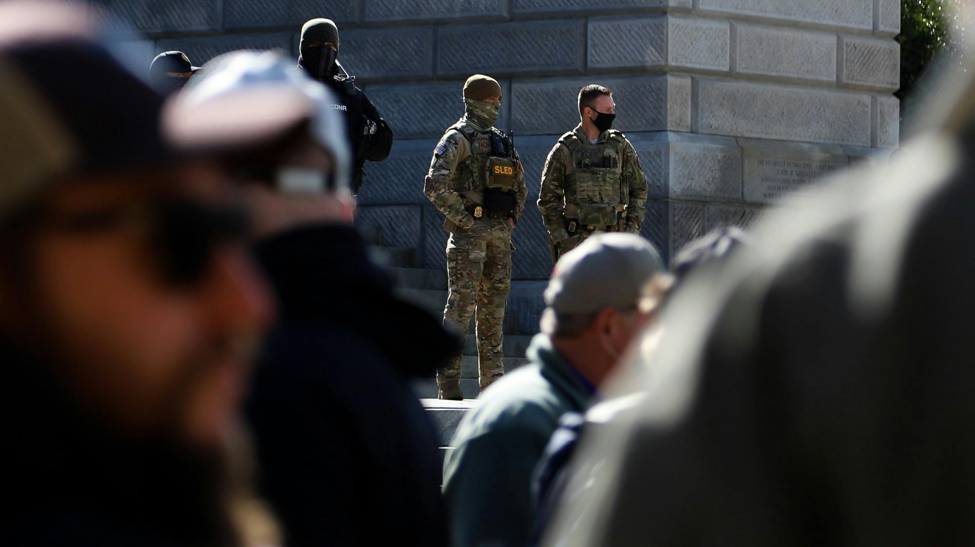 Two officers, one SLED and other unknown, watch the rally from behind the barriers. Police presence increased throughout the rally.&nbsp;
