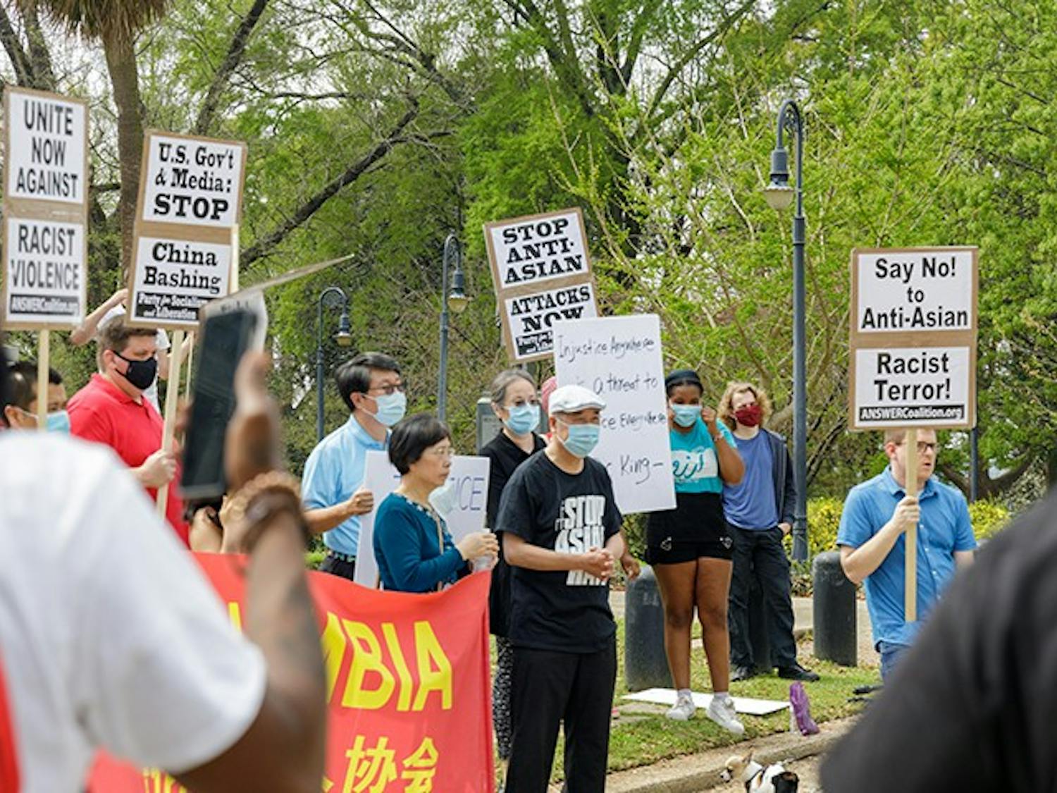  A group holds signs in protest of Asian hate that is happening within Asian communities.

