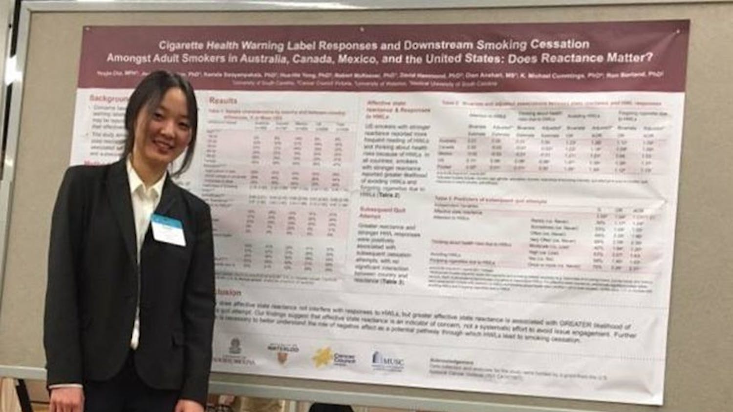 Yoojin Cho stands in front of her research presentation at the Society for Research on Nicotine and Tobacco conference.