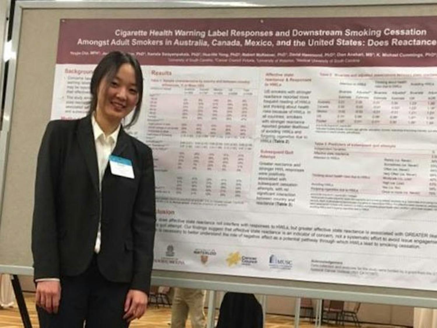 Yoojin Cho stands in front of her research presentation at the Society for Research on Nicotine and Tobacco conference.