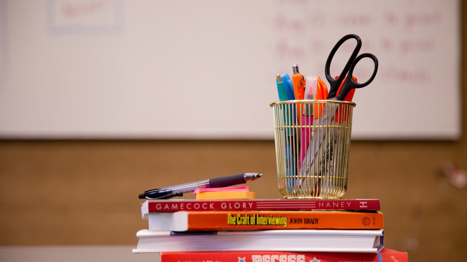A stack of school supplies with a whiteboard in the background taken on July 5, 2022. 