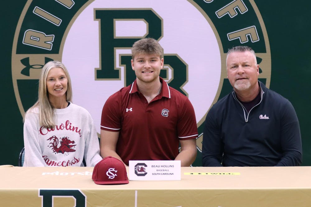 <p>First baseman Beau Hollins poses for a picture with his parents officially committing to the Gamecock's baseball team on Nov. 8, 2023. Hollins is currently a member of the River Bluff High School baseball team in Lexington, S.C., which captured a 5A state championship last season.</p>