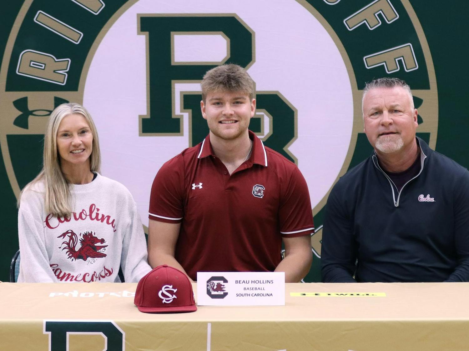 First baseman Beau Hollins poses for a picture with his parents officially committing to the Gamecock's baseball team on Nov. 8, 2023. Hollins is currently a member of the River Bluff High School baseball team in Lexington, S.C., which captured a 5A state championship last season.