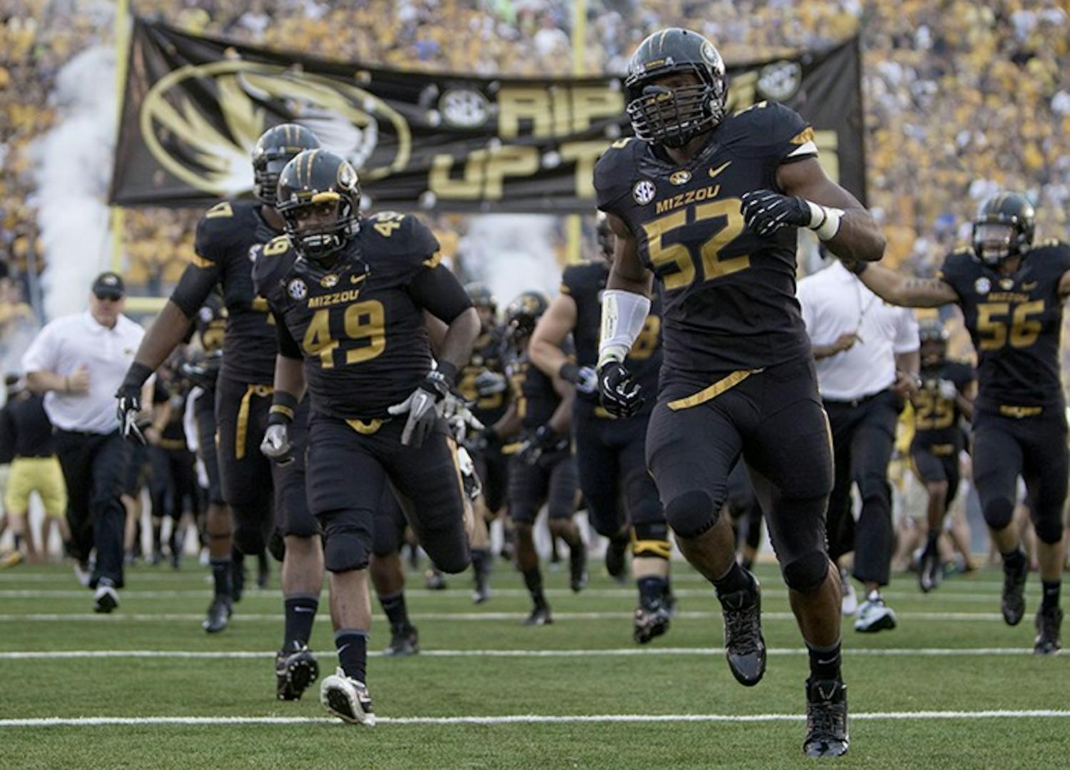 Missouri Tigers linebacker Denzel Martin (49) and defensive lineman Michael Sam (52) lead the charge onto the field at the start of the game against Murray State at Faurot Field in Columbia, Missouri, Saturday, August 31, 2013. (Shane Keyser/Kansas City Star/MCT)
