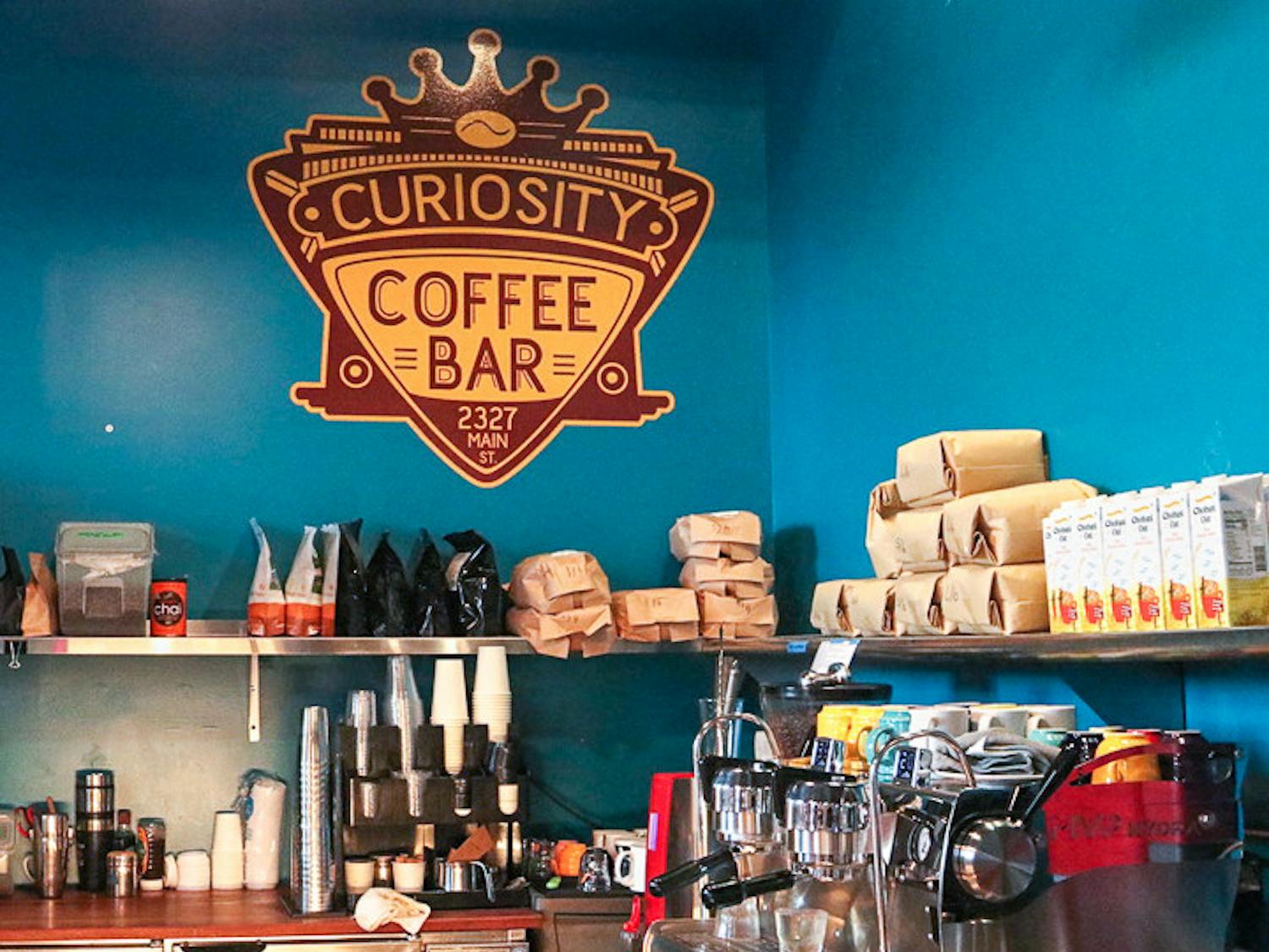 The Curiosity Coffee logo above the coffee bar inside the cafe. Curiosity coffee is located at 2727 Main Street in Columbia, SC.