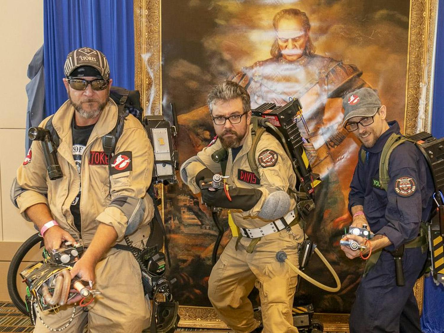 Ron Stokes (left), Andrew Davis (center) and Chris Young (right) pose in front of a painting of "Vigo the Carpathian" from "Ghostbusters 2." The three are members of the Columbia branch of a non-profit group, South Carolina Ghostbusters, who attend and run charity events and help acquire medical treatments for people in need around the Midlands.