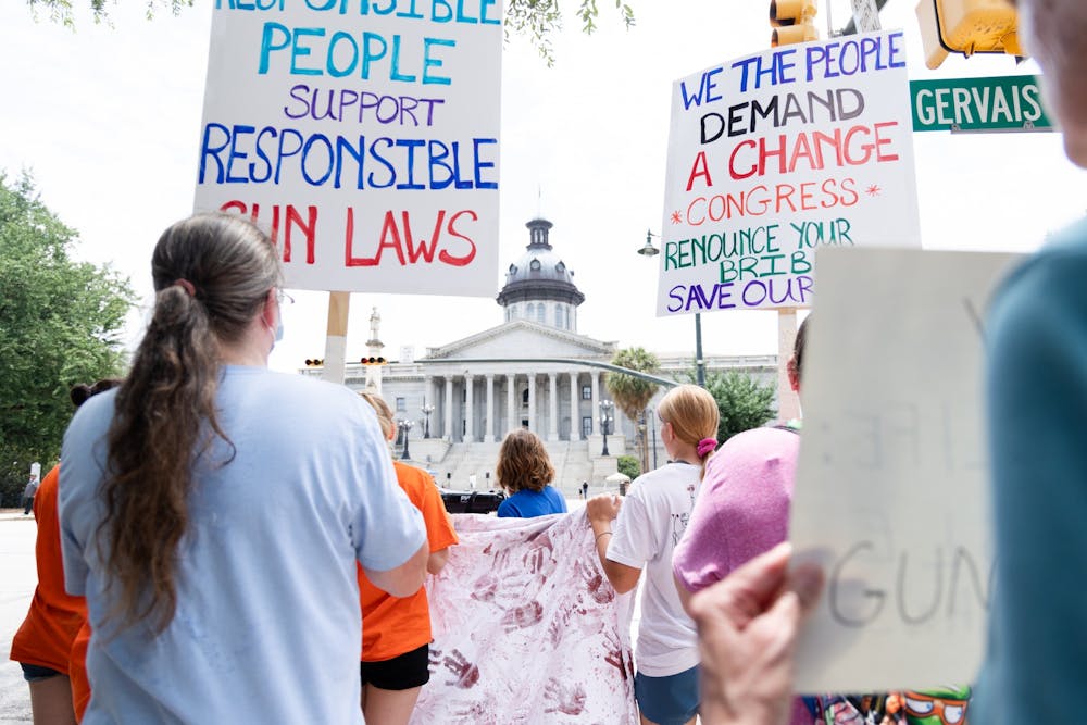 <p>Lily Lawther leads a group of participants from the March for Our Lives rally toward the Statehouse on June 11, 2022. The group marched down Main Street and around the Statehouse to advocate for stricter gun laws.&nbsp;</p>