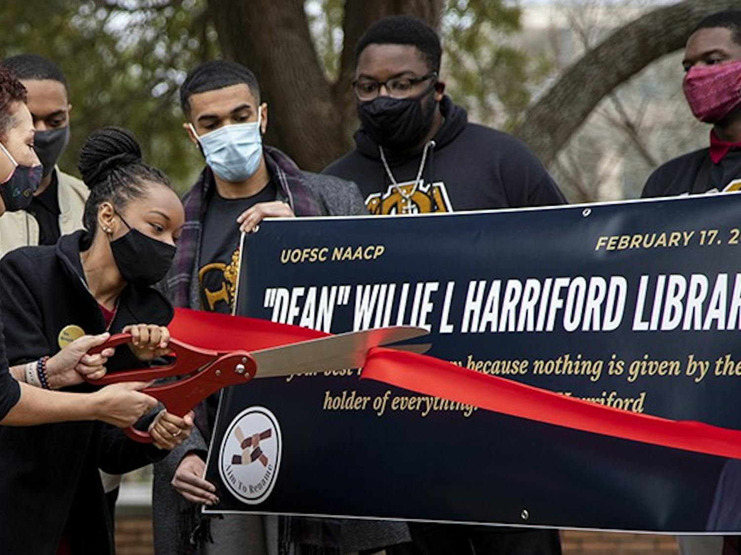 NAACP chapter President Caley Bright cuts the ribbon during the NAACP press conference. 