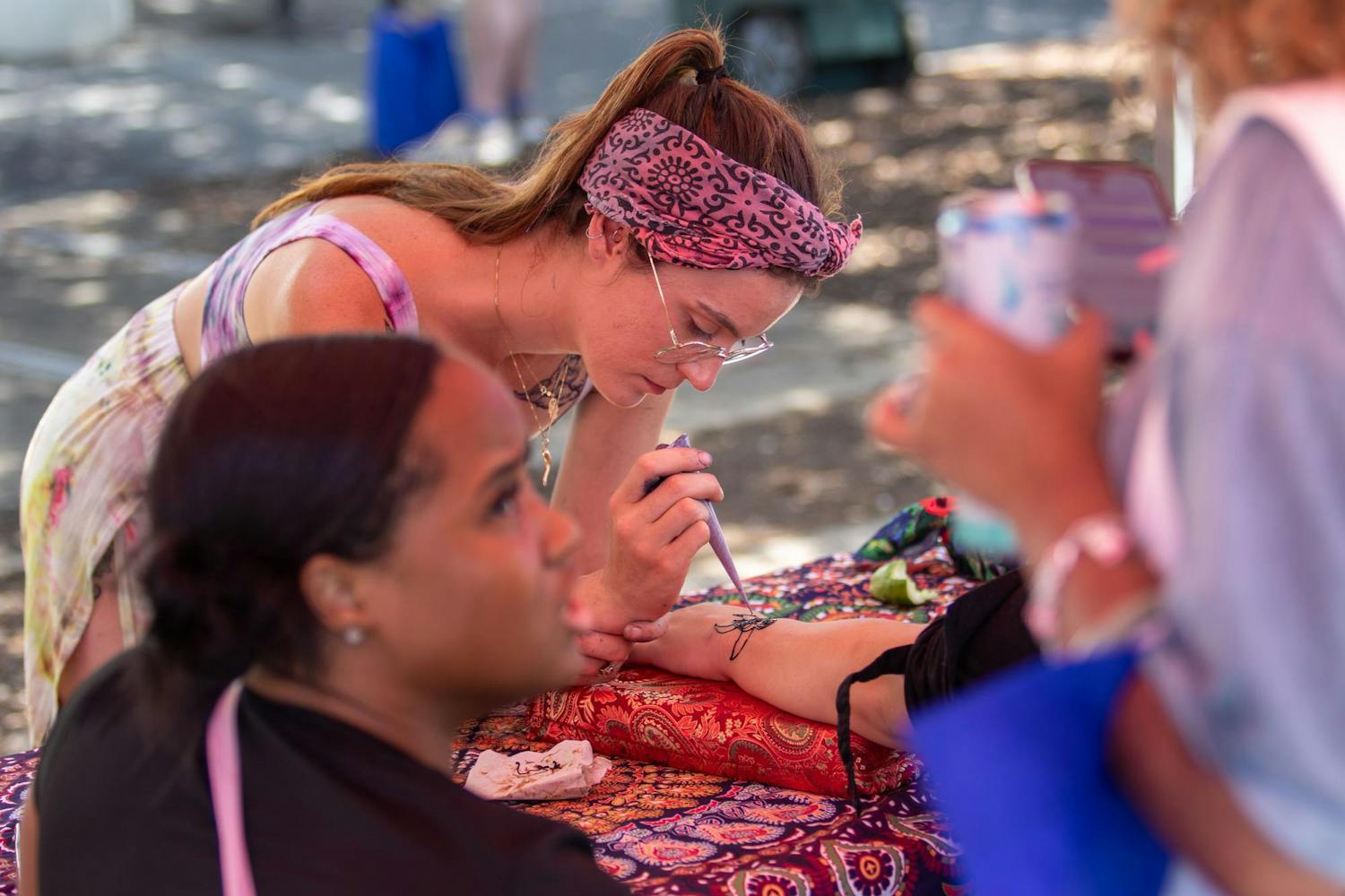 Catherine Baz, owner of 7 Moon Mystics, doing henna at Outfest on June 1, 2024. Outfest, hosted by South Carolina Pride, features many different vendors from around the Columbia area, offering a variety of goods and services for attendees.