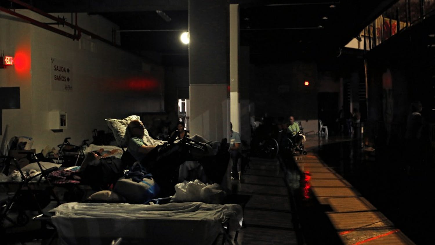 Evacuees rest in almost complete darkness on the ground floor of the Roberto Clemente Coliseum, a major shelter in San Juan, Puerto Rico, where evacuees were forced to move when the roof began to leak during Hurricane Maria, on Wednesday, Sept. 20, 2017. (Carolyn Cole/Los Angeles Times/TNS)