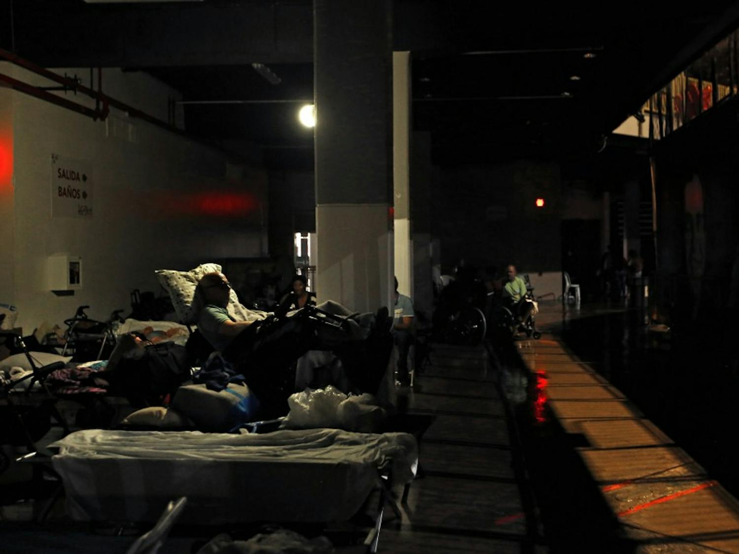 Evacuees rest in almost complete darkness on the ground floor of the Roberto Clemente Coliseum, a major  shelter in San Juan, Puerto Rico, where evacuees were forced to move when the roof began to leak during Hurricane Maria, on Wednesday, Sept. 20, 2017. (Carolyn Cole/Los Angeles Times/TNS) 