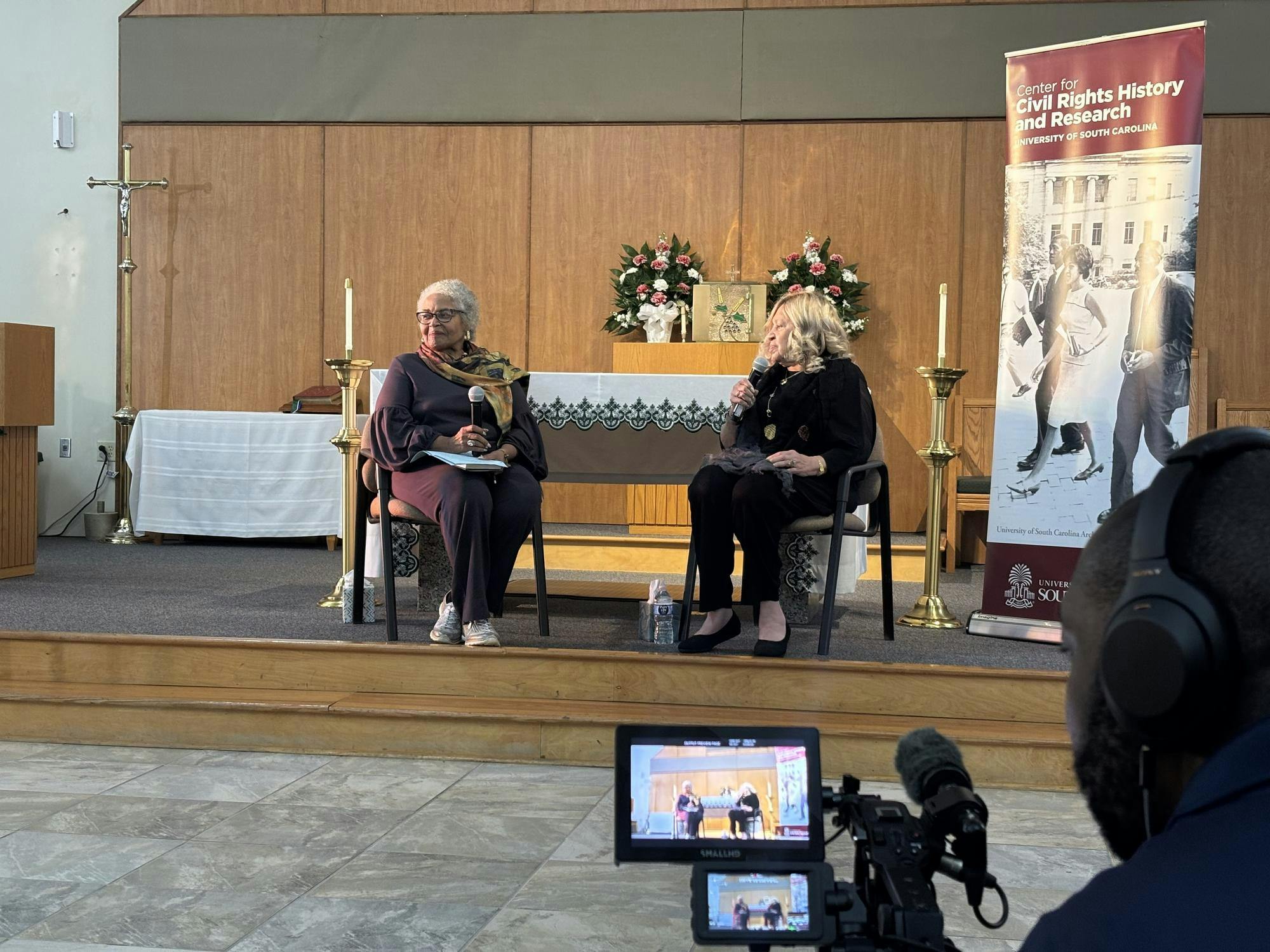 Beryl Dakrs (left) leads a discussion with Henrie Monteith Treadwell (right) at St. Martin de Porres Catholic Church Oct 24. 
