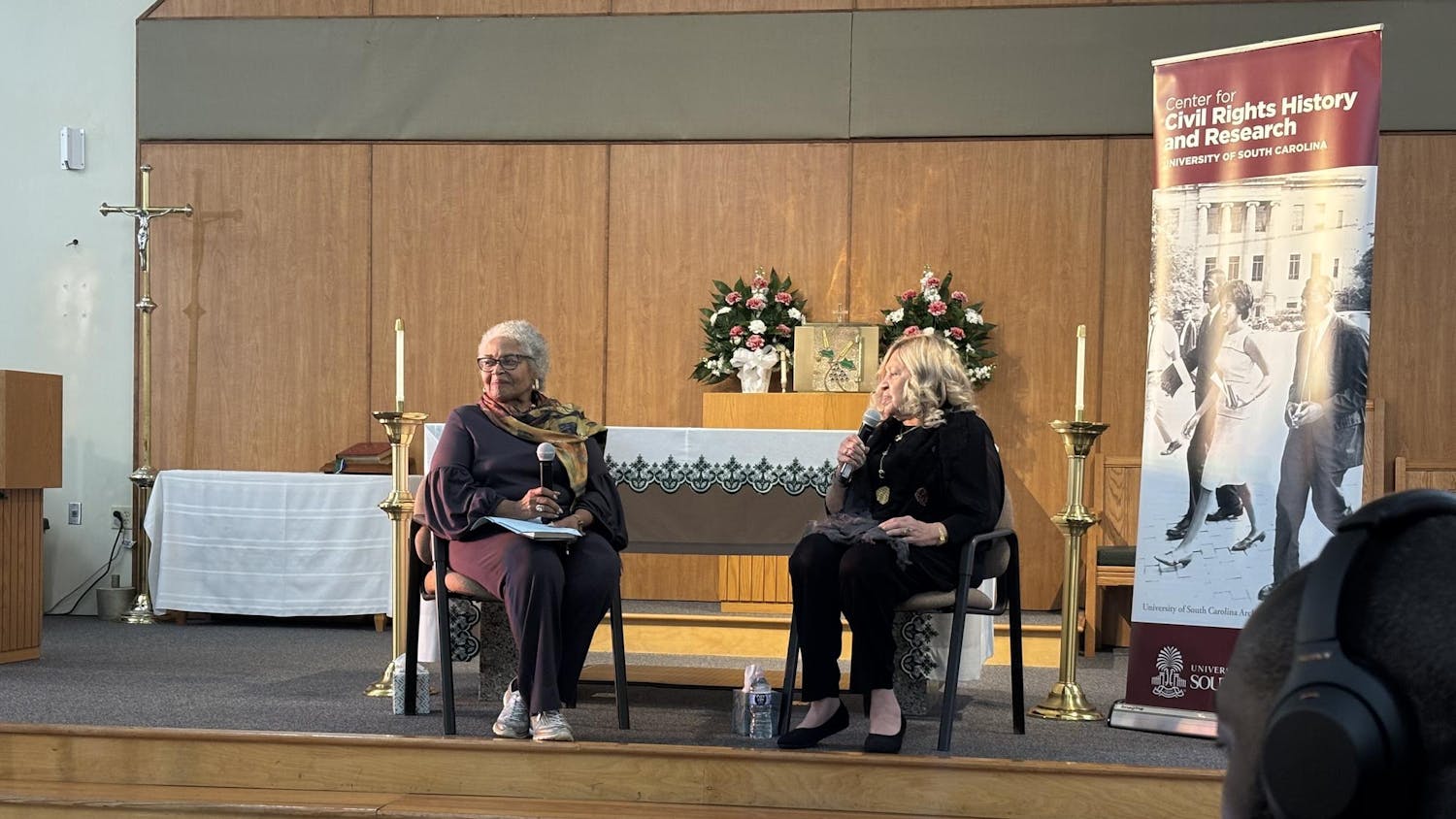 Beryl Dakrs (left) leads a discussion with Henrie Monteith Treadwell (right) at St. Martin de Porres Catholic Church Oct 24.