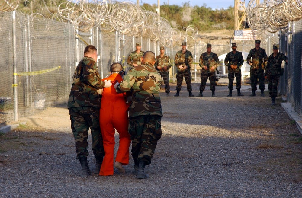 Taliban and al-Qaida detainees in orange jumpsuits sit in a holding area during in-processing to the temporary detention facility on Jan. 18, 2002, in Guantanamo Bay, Cuba. The Senate Select Committee on Intelligence released a report on the CIA's interrogation practices. The report said the CIA misled Americans and government policymakers about the effectiveness of the program that was secretly put into place after the 9/11 terror attacks. (Shane T. McCoy/ZUMA/TNS) 