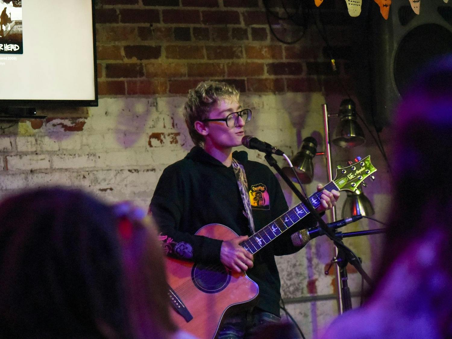 A local artist sings and plays guitar on stage at Curiosity Coffee Bar’s Open Mic night on Oct. 15, 2024. This event is one of many hosted throughout Columbia by South Carolina Pride, the main organization in charge of the city’s Famously Hot pride week.