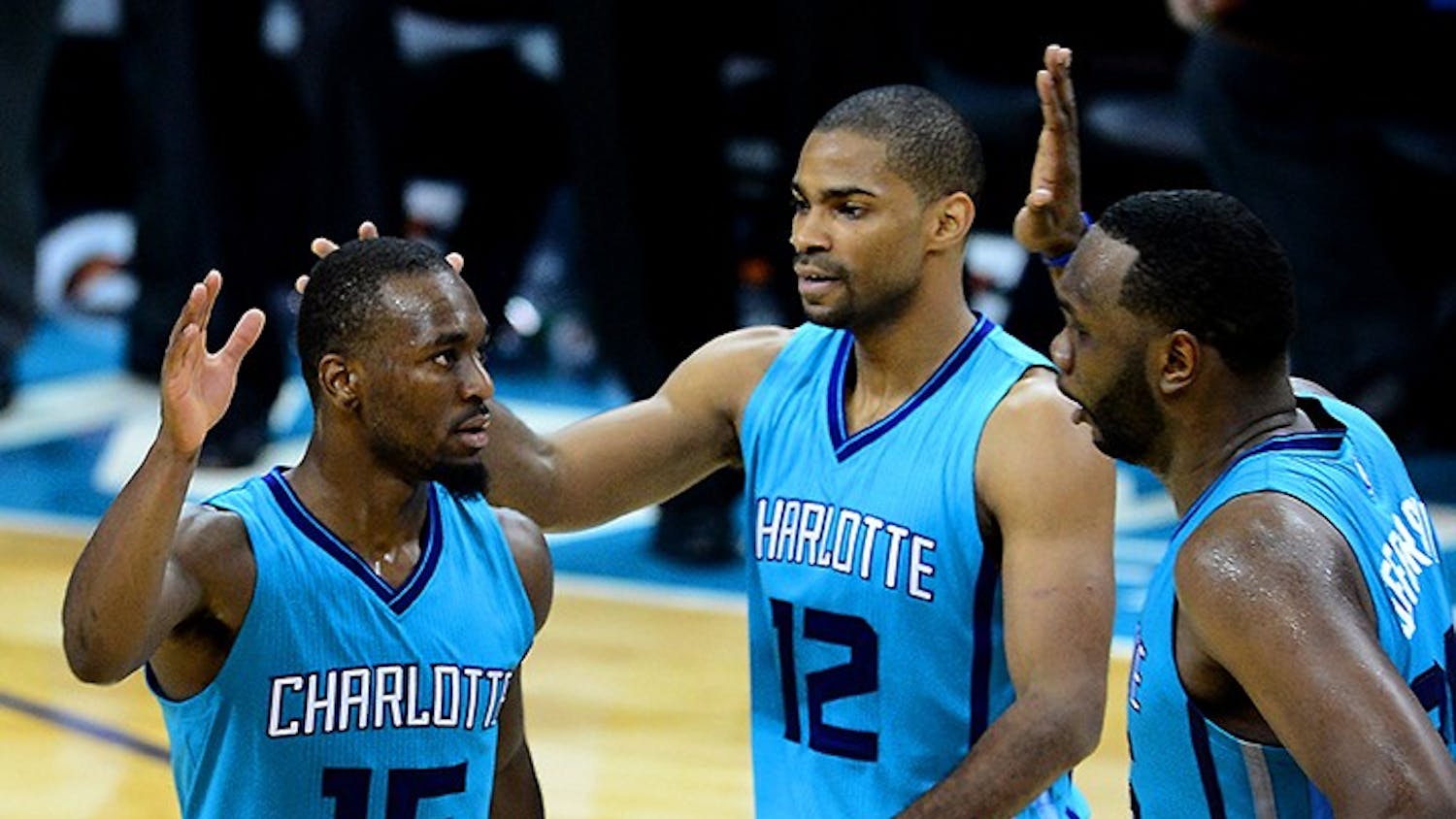 The Charlotte Hornets' Kemba Walker (15) is congratulated by teammates Gary Neal (12) and Al Jefferson after hitting the game winning-basket against the Milwaukee Bucks on Wednesday, Oct. 29, 2014, at Time Warner Cable Arena in Charlotte, N.C. The Hornets won, 108-106, in overtime. (Jeff Siner/Charlotte Observer/MCT)