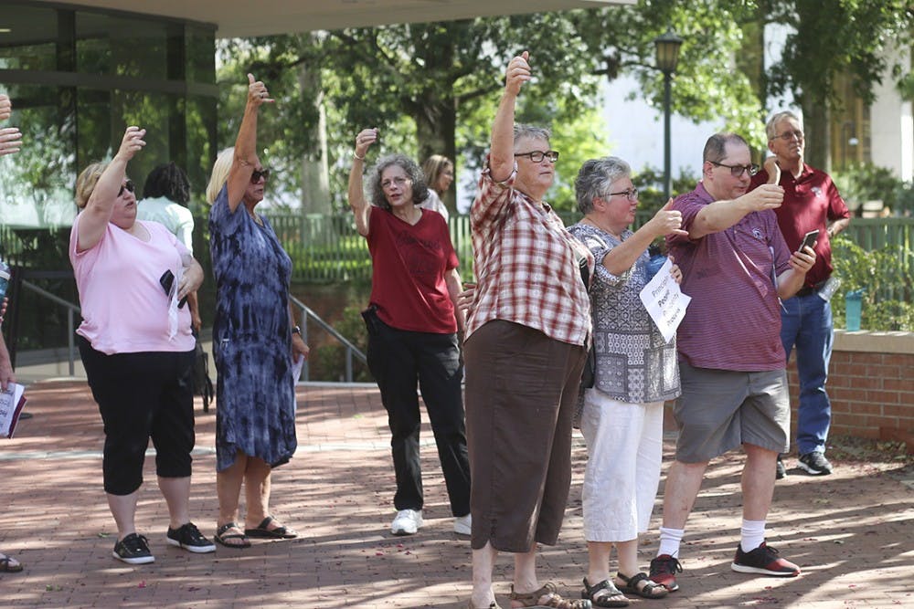 Rally attendees sing the alma mater at the end of the rally at Russell House on Wednesday.&nbsp;