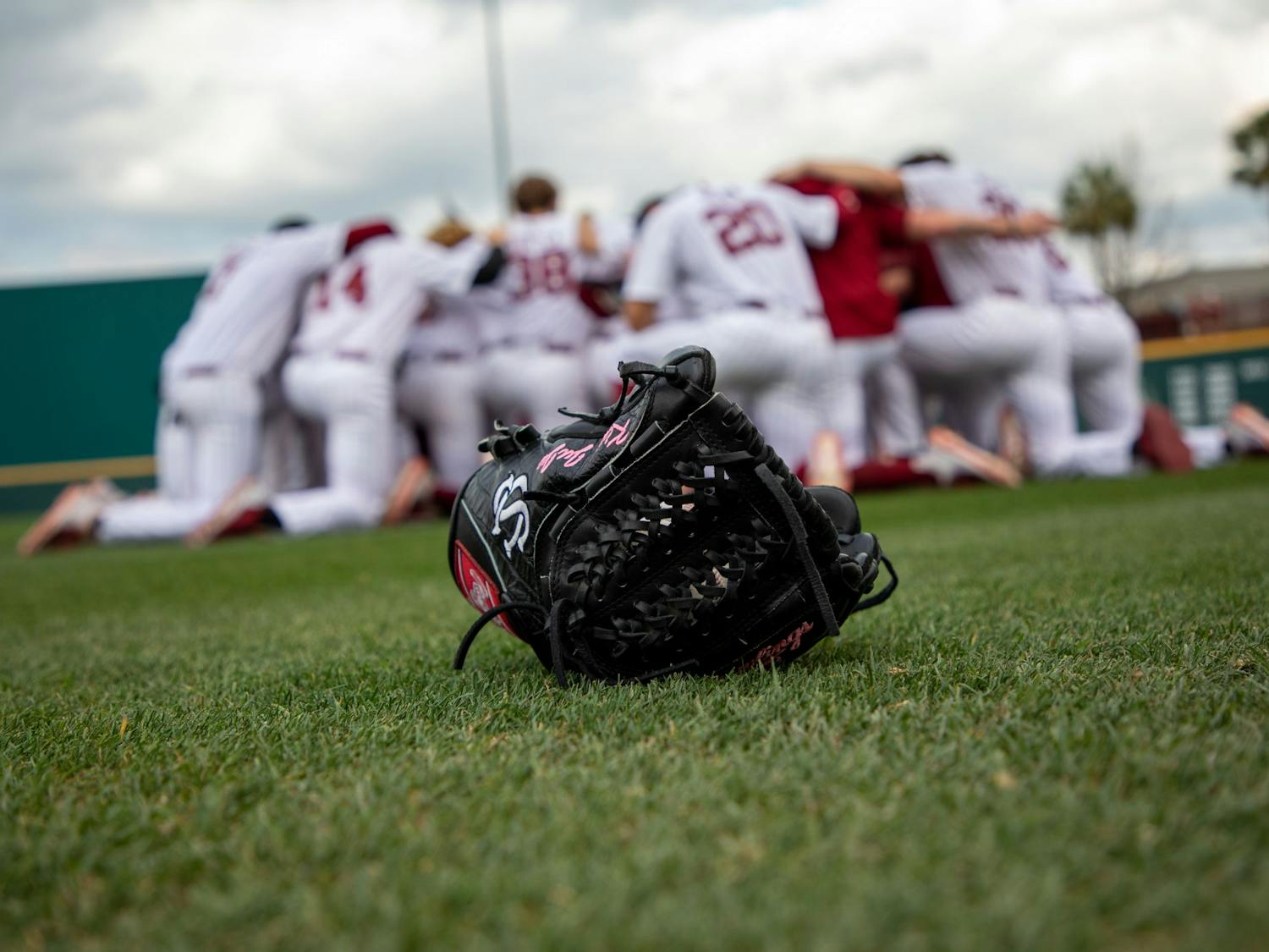 FILE—Closeup of a glove as the South Carolina baseball team huddles before a game against Appalachian State on Tuesday, March 1, 2022. The Gamecocks defeated the Mountaineers 9-6.