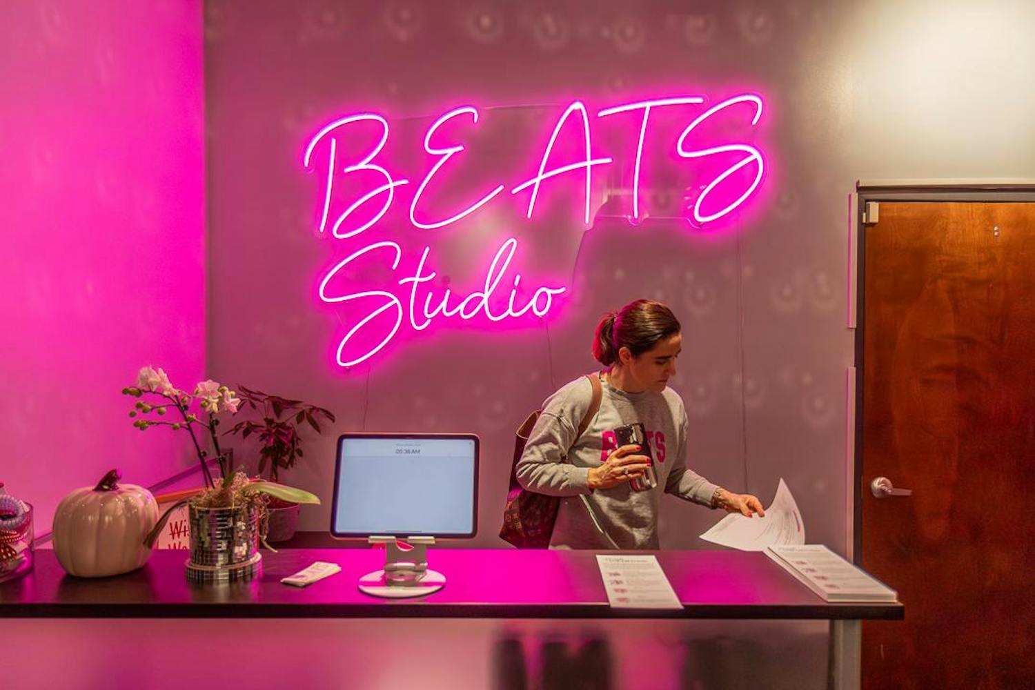 Studio owner Meredith Trout grabs an information sheet from the front desk of BEATS Barre Studio on Nov. 8, 2023. Trout founded BEATS in 2018, teaching out of her home studio in Lexington, North Carolina, and later moving to Columbia, South Carolina, in 2022 to continue giving personal lessons from home before she opened up her studio on Gervais Street in September 2023.