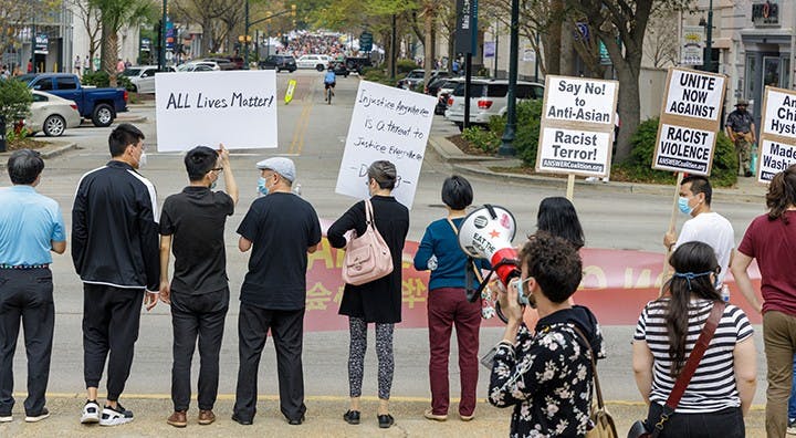 The group of protestors faces the street while second-year history student Anson Foster talks behind them on a megaphone.