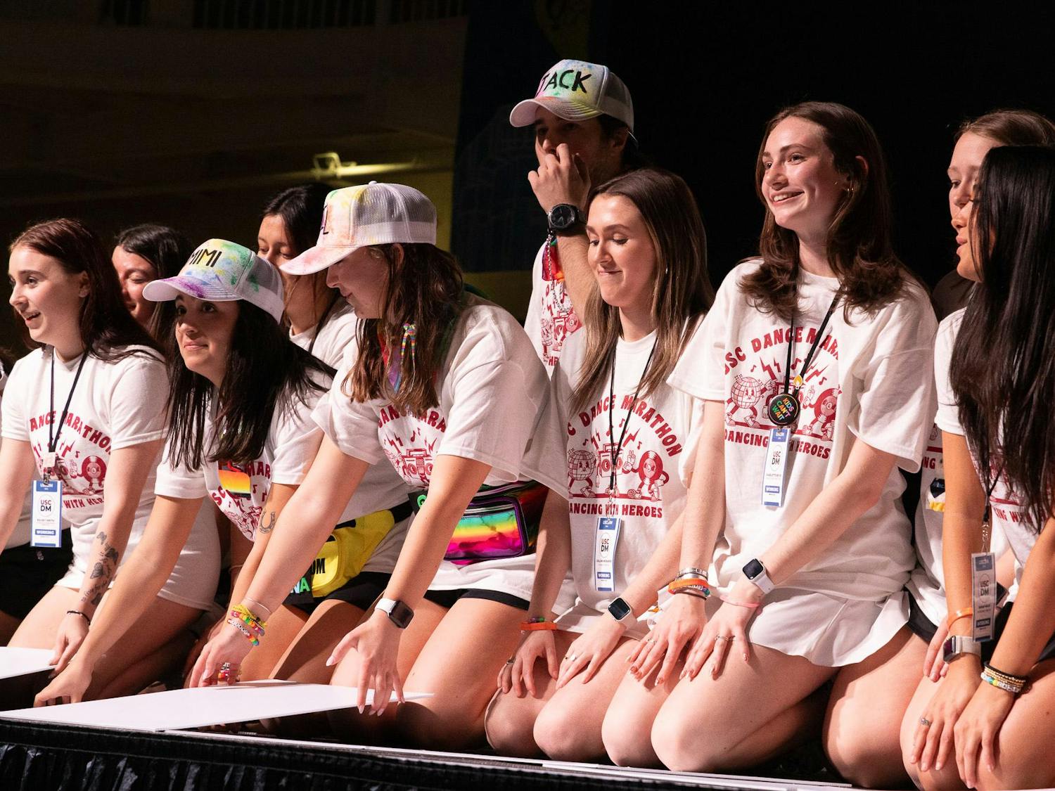 During the Dance Marathon main event, the atmosphere was joyful at the Strom Thurmond Wellness and Fitness Center on Saturday, Feb. 24, 2024. Students sit on the edge of the stage before the total funds raised for Prisma Health Children's Hospital are revealed.