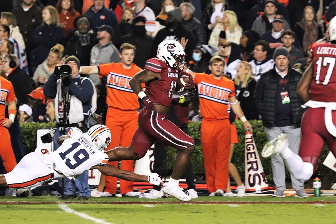 Redshirt senior ZaQuandre White runs out of the reach of Auburn safety Bydarrius Knighten (19) to score a touchdown. The Gamecocks defeated the Tigers 21-17 and are now bowl eligible for the first time since 2018.&nbsp;