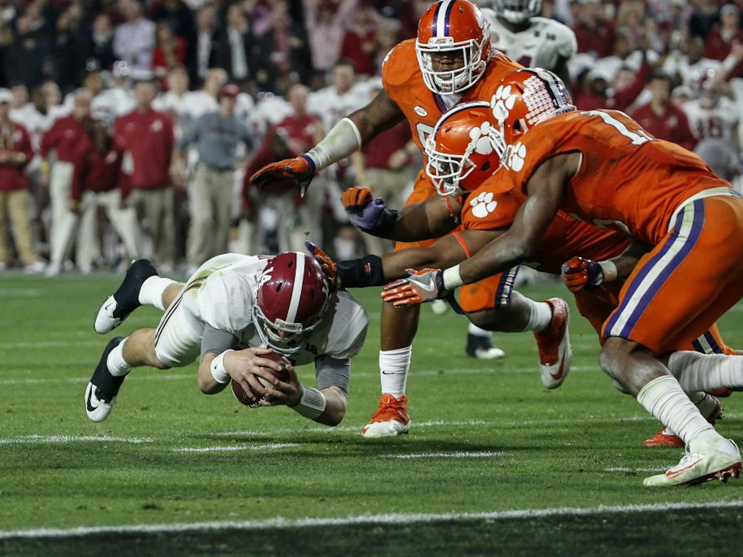 Alabama Crimson Tide quarterback Jake Coker (14) dives for a first down during the College Football Playoff National Championship game between the Alabama Crimson Tide and the Clemson Tigers at the University of Phoenix Stadium on Jan. 11, 2016 in Glendale, Ariz. Alabama won 45-40. (Tim Warner/CSM/Zuma Press/TNS)