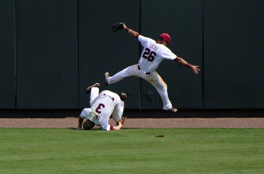 Saiko leaps over English to avoid colliding with him after English makes a diving catch.