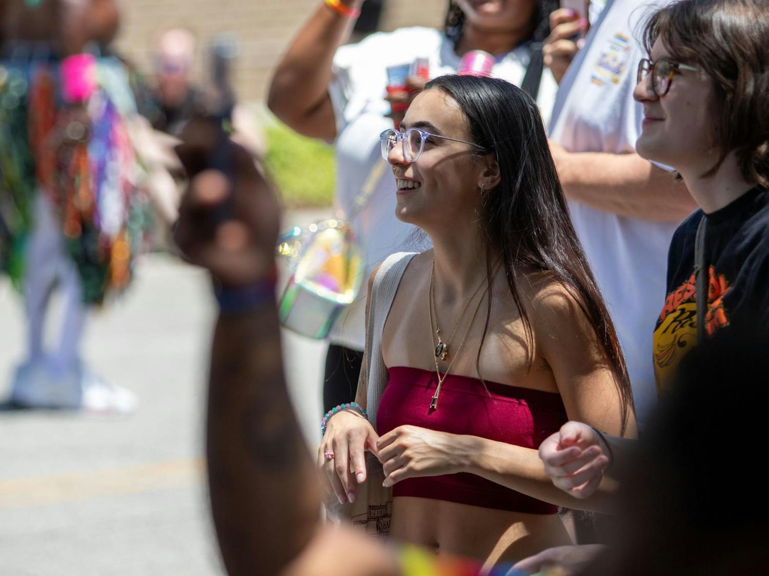 A spectator smiles while watching the drag competition during Outfest on June 1, 2024. Attendees had the chance to enjoy food, drinks, and watch the drag pageant throughout the day.