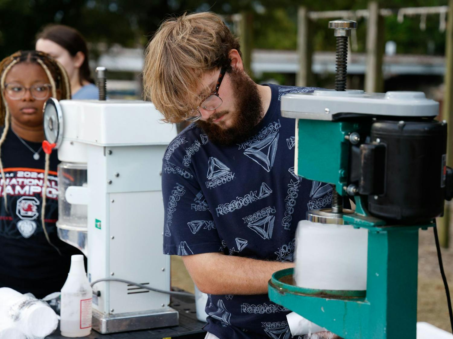 A student worker shaves off ice to prepare a snow cone at Blatt Bonanza on Blatt Field on Sept. 18, 2024. Free food was available for all students who attended the event.