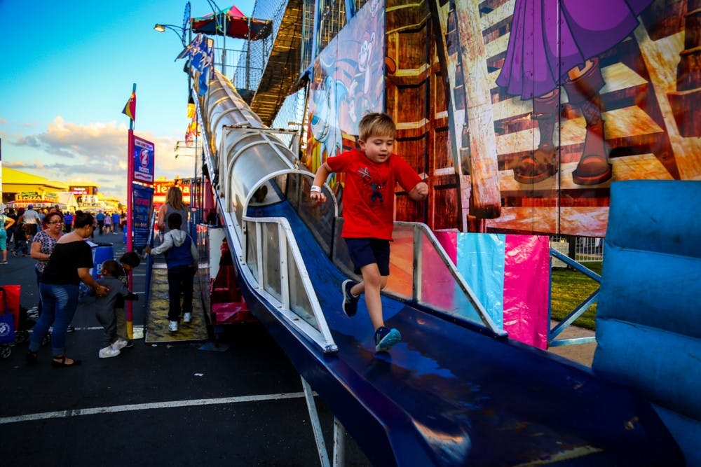 A kid runs down a slide at State Fair.