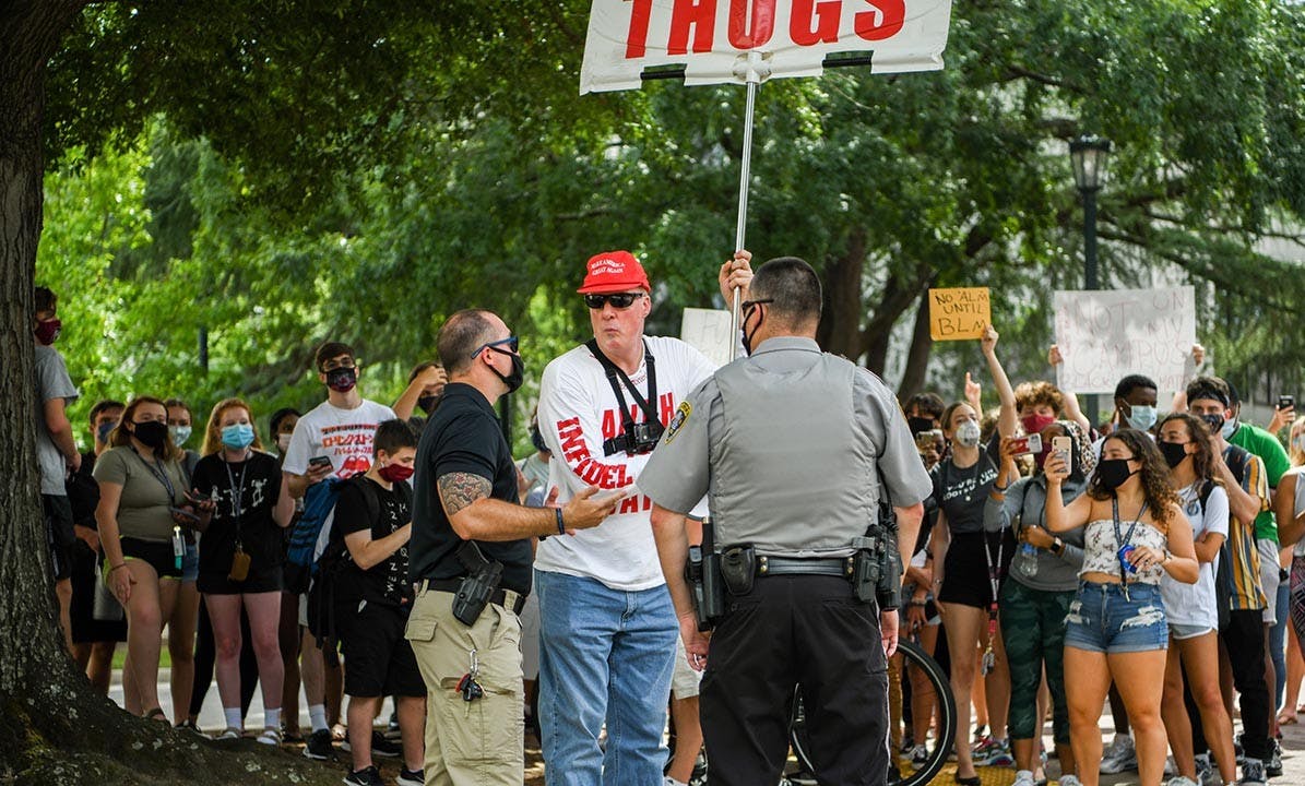 Jim Gilles talks to police about being escorted out after he decided to leave Green Street Friday afternoon. Students cheered behind him as this happened.