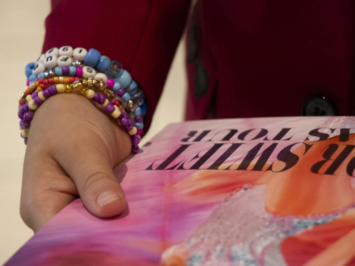 FILE — Channing Berry, 11, holds a free Taylor Swift poster during the opening night of Taylor Swift: The Eras Tour movie at AMC Harbison 14 on Oct. 13, 2023. Berry was sporting a "Red" era coat and multiple friendship bracelets.