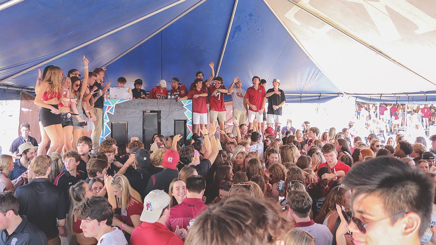 USC students gather under a fraternity tent at the Fraternity Lot, a popular tailgate event held before every home game. The frat lot has faced controversy for being an unsafe environment for underage drinking students, but it still serves as a defining pregame event for thousands of partying USC students.