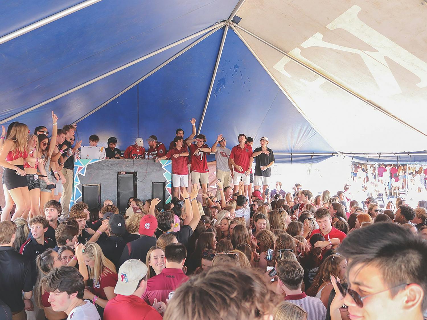 USC students gather under a fraternity tent at the Fraternity Lot, a popular tailgate event held before every home game. The frat lot has faced controversy for being an unsafe environment for underage drinking students, but it still serves as a defining pregame event for thousands of partying USC students.
