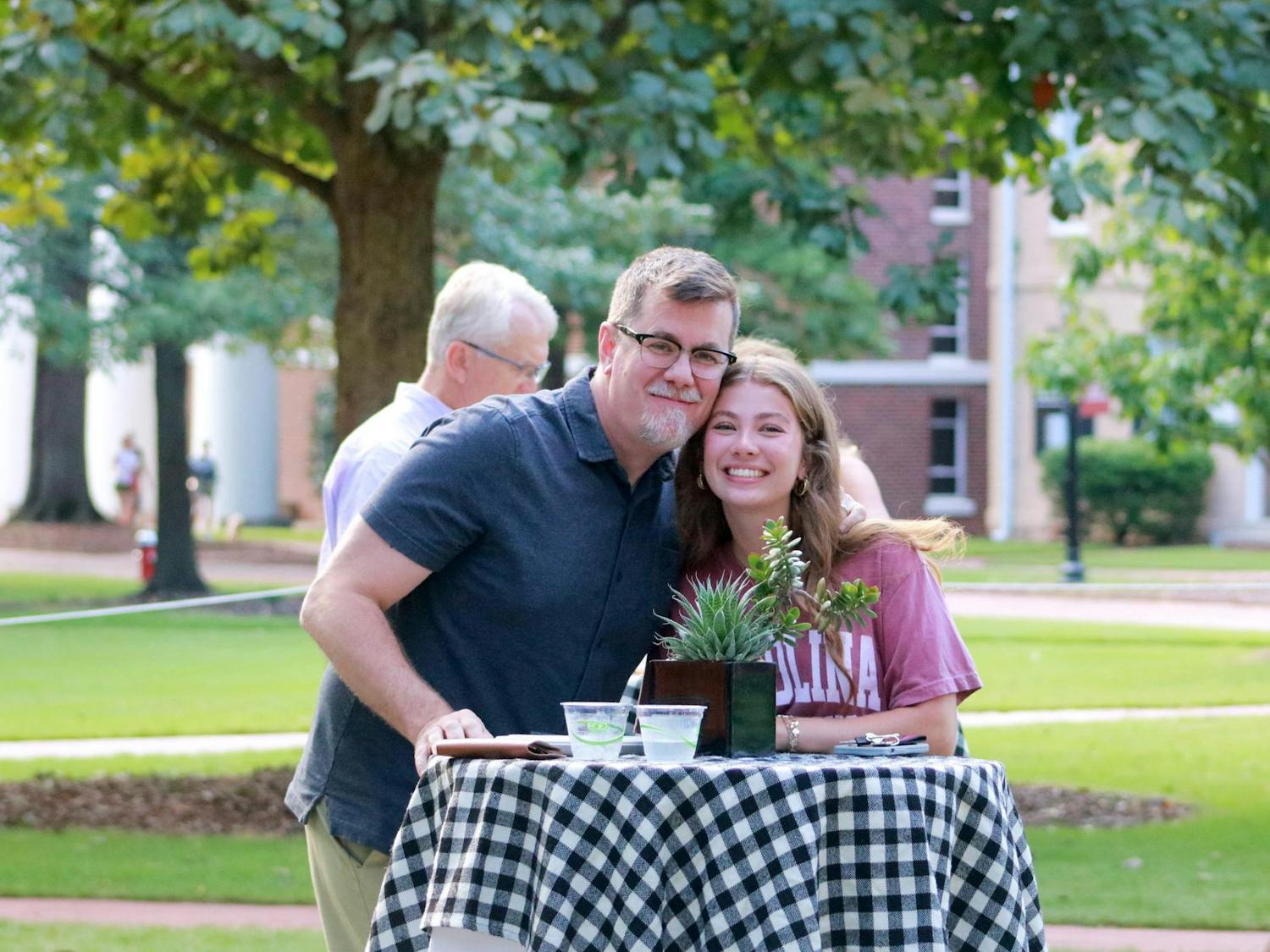 A USC student and her father smile for the camera while attending the 'President Meet and Greet' on the Horseshoe on Sept. 20, 2024. Students and their families had the chance to meet and talk with USC's president for one of the Family Weekend events.
