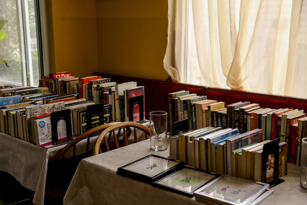 <p>Books in a variety of genres are lined up inside Baan Sawan Thai Bistro on Devine Street on Feb. 21, 2023. The bistro began selling used books to make up for lost revenue after restricting its business hours to only weekend dinner service.</p>