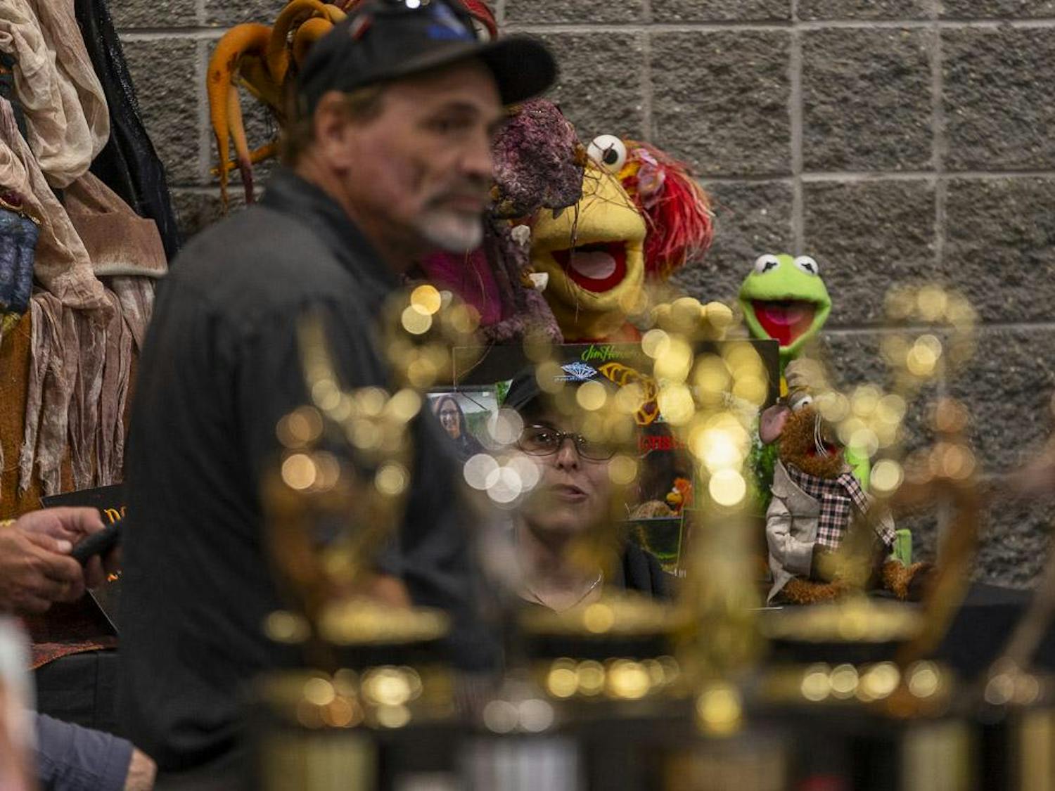 Red Fraggle from "Fraggle Rock" (left) and Kermit the Frog (right) sit in the background of the Bill Diamond Productions booth at the South Carolina Horror Convention on September 16, 2023. Bill Diamond, seen in the foreground, is an award artist, puppeteer and producer who has worked on a plethora of films and television shows including "The Muppets," "Little Shop of Horrors" and "Dark Crystal."