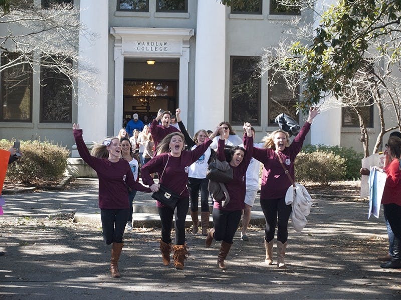 Students in the higher education and student affairs graduate program run out of Wardlaw College after taking their exams.