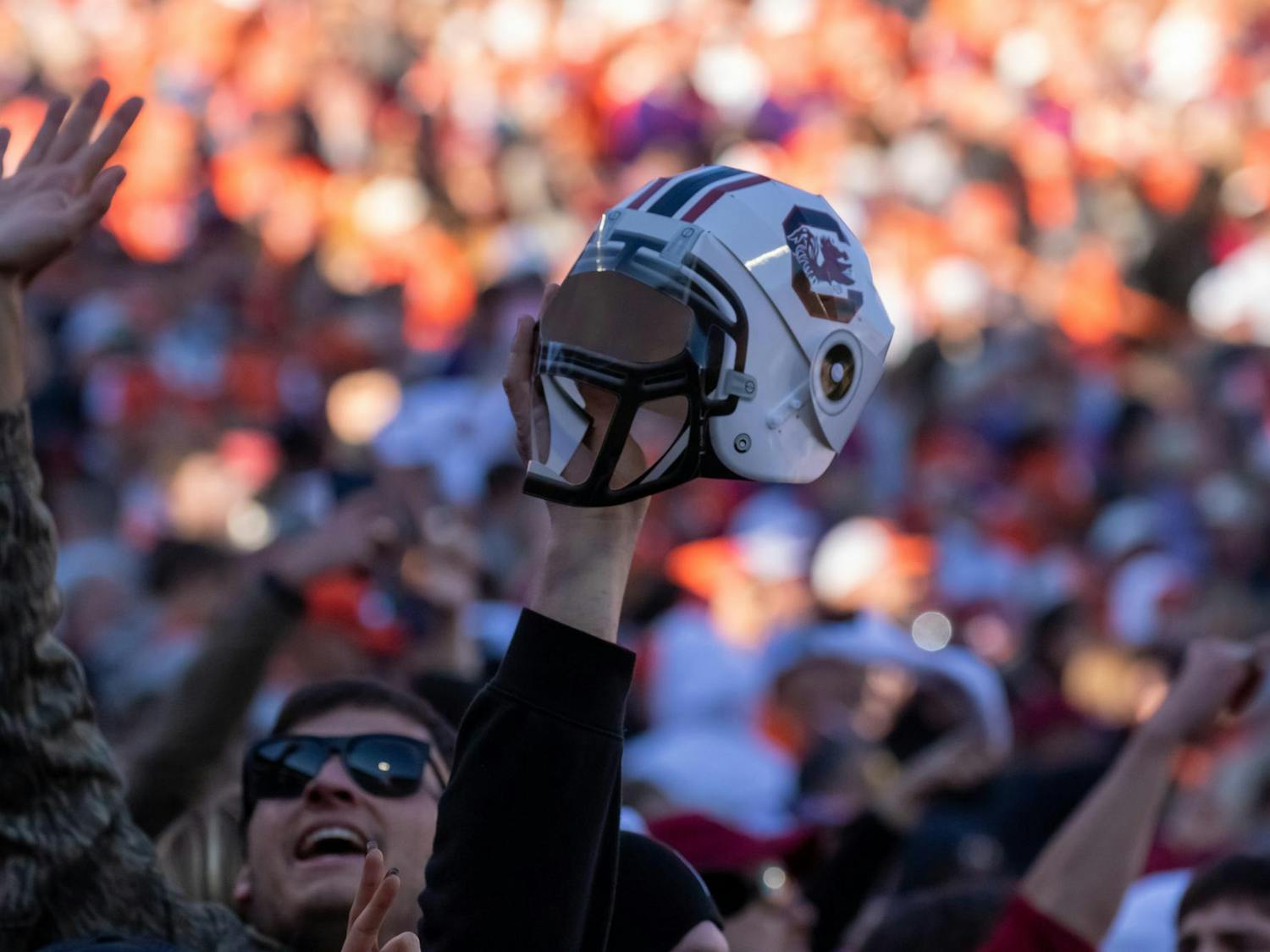 A fan holds a miniature South Carolina football helmet as the Gamecocks defeat the Tigers in the Palmetto Bowl on Nov. 30, 2024 at Memorial Stadium. Many fans stormed the field after the Gamecocks defeated the Tigers 17-14.