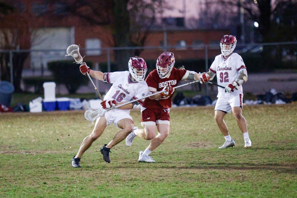 <p>Sophomore midfielder Jaden Mullins pushes against a defending player while carrying the ball during the game against Boston College on Feb.7, 2025. The Gamecocks defeated the Eagles 10-9.</p>