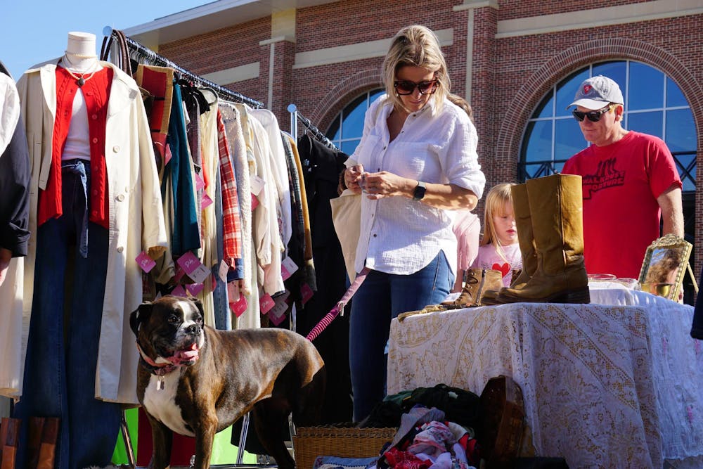 <p>Columbia resident Ashley Floyd and her dog Aliza look through clothing at Bullseye Vintage market in front of Segra Park on Nov. 16, 2025. The event is hosted by the team behind Soda City Market and will add new antique and vintage vendors to the market every third Sunday.</p>