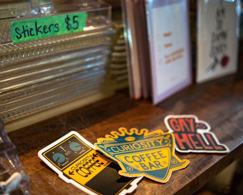A few of the stickers sold at Curiosity Coffee Bar. A cute and colorful collection of merchandise can be found inside the cafe, including pride-inspired stickers, greeting cards, and more.