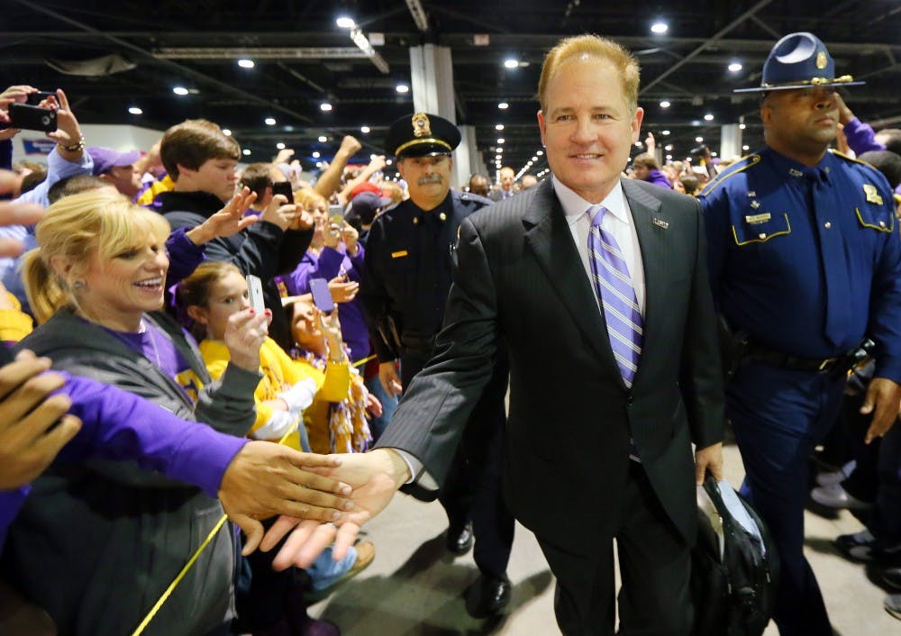 LSU head coach Les Miles slaps hands with fans during the Team Walk as he and the LSU Tigers arrive for the Chick-fil-A Bowl in Atlanta, Georgia on Monday, December 31, 2012. (Curtis Compton/Atlanta Journal-Constitution/MCT)