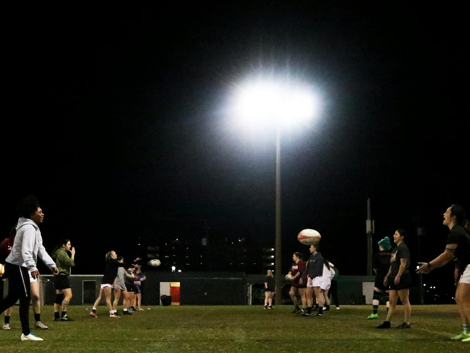 The Gamecocks women’s rugby team stretches and warms up for its Tuesday night practice at the Bluff Road Park practice fields on Feb. 7, 2023. The team has been preparing for its upcoming 2023 spring season since October 2022.