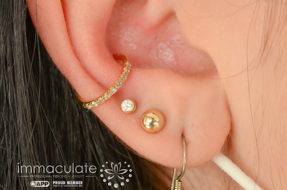 <p>A customer displays their intricate ear design after being pierced and styled at Immaculate Body Piercing. Founder and owner Sarah Wooten prioritizes the safety and comfort of her clients when visiting her shop.</p>