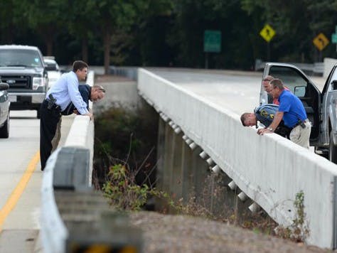 Investigators look over the bridge on State 93 over the Seneca River in Clemson Tuesday, September 23, 2014 where the body of Clemson student Tucker W. Hipps was found yesterday.